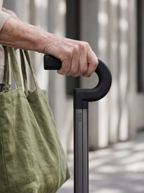 A hand resting on the Rise cane handle while carrying a tote